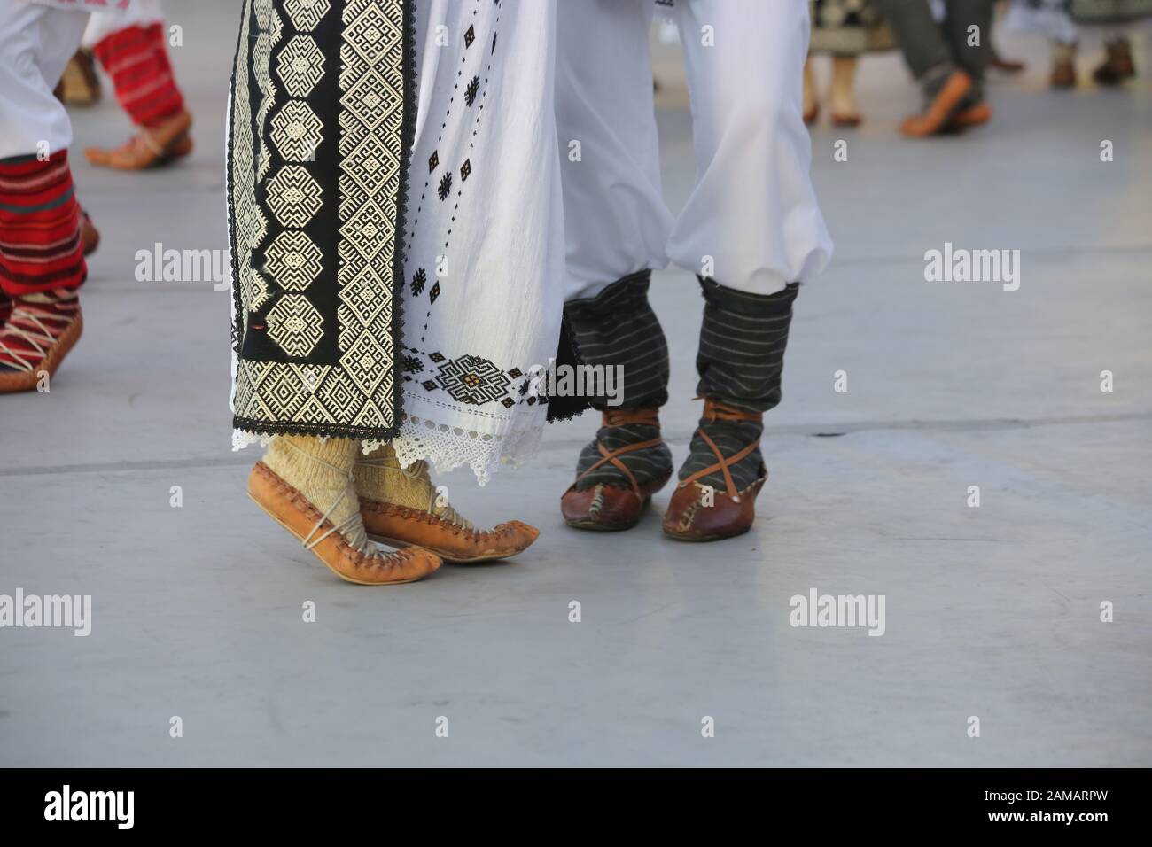 Dancersfeet in una danza tradizionale rumena indossando costumi tradizionali belli. Primo piano di scarpe folcloristiche. Foto Stock