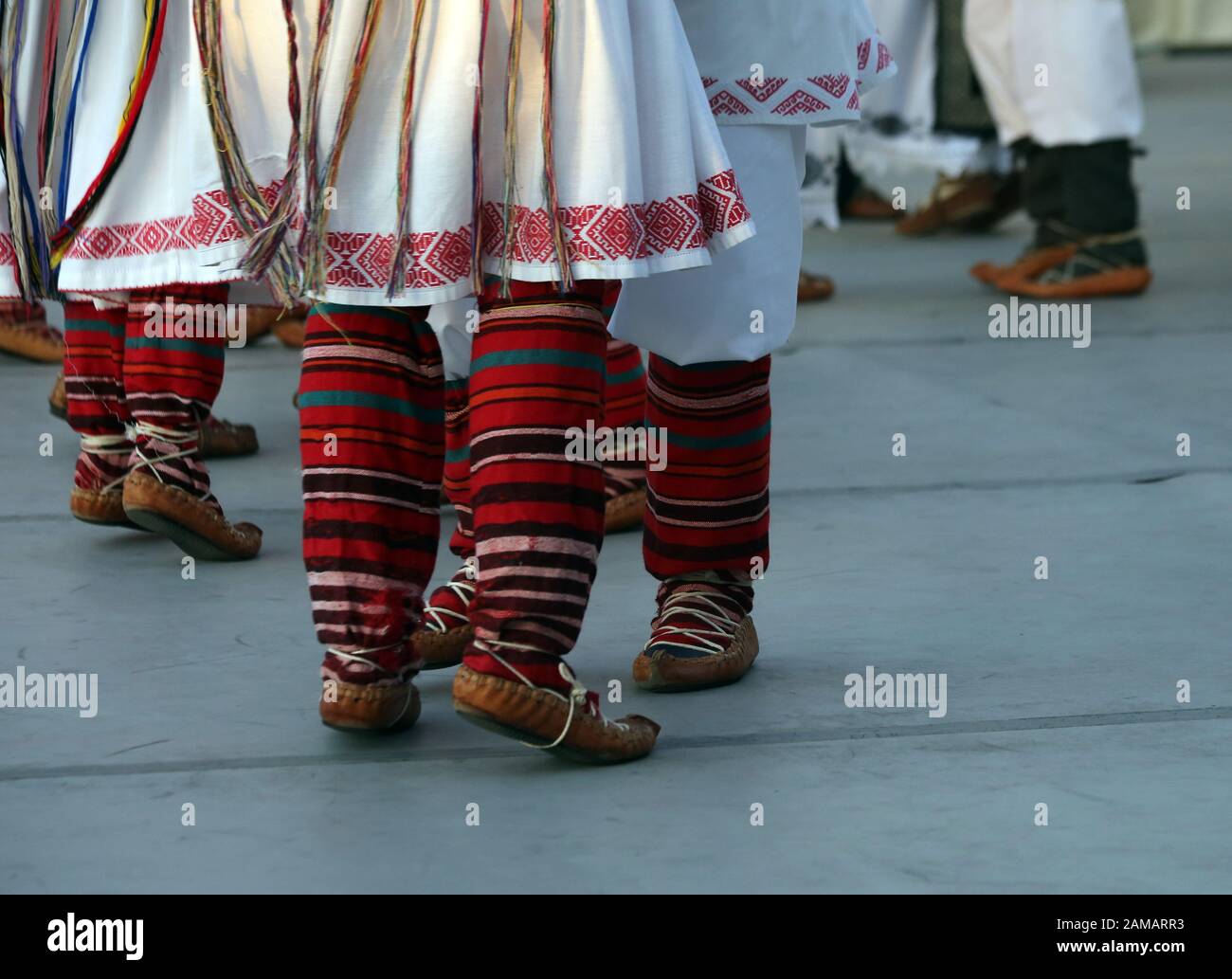 I ballerini professionisti del Timisul Folklore Ensemble tengono le mani in una danza tradizionale rumena indossando costumi tradizionali belli. Foto Stock