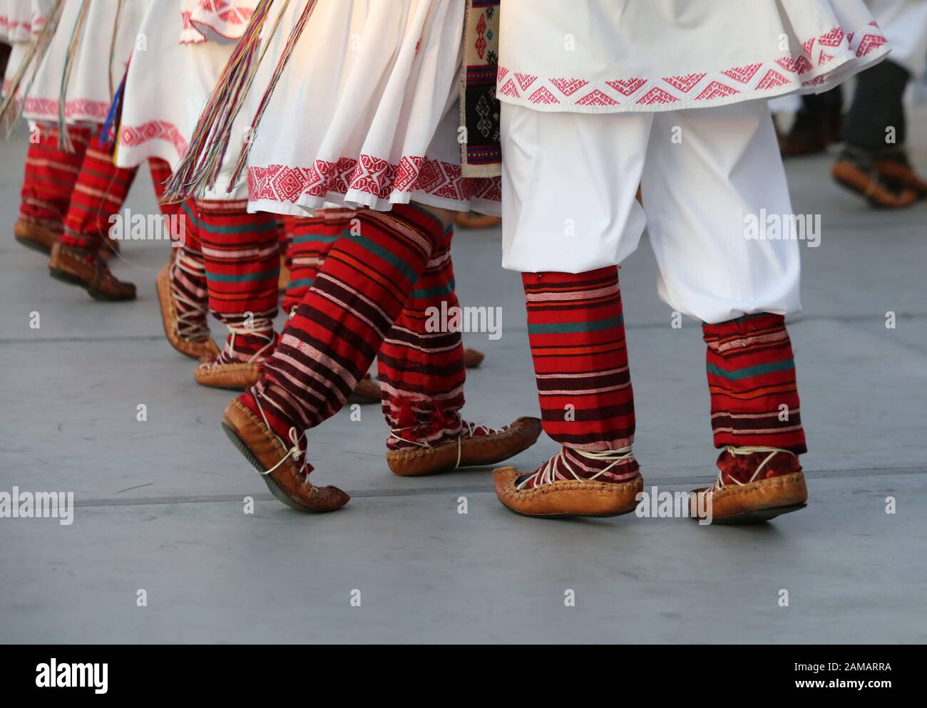 I ballerini professionisti del Timisul Folklore Ensemble tengono le mani in una danza tradizionale rumena indossando costumi tradizionali belli. Foto Stock
