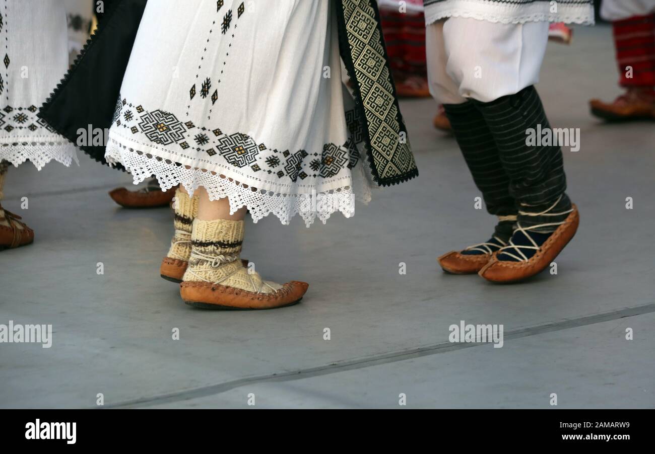 Dancersfeet in una danza tradizionale rumena indossando costumi tradizionali belli. Primo piano di scarpe folcloristiche. Foto Stock