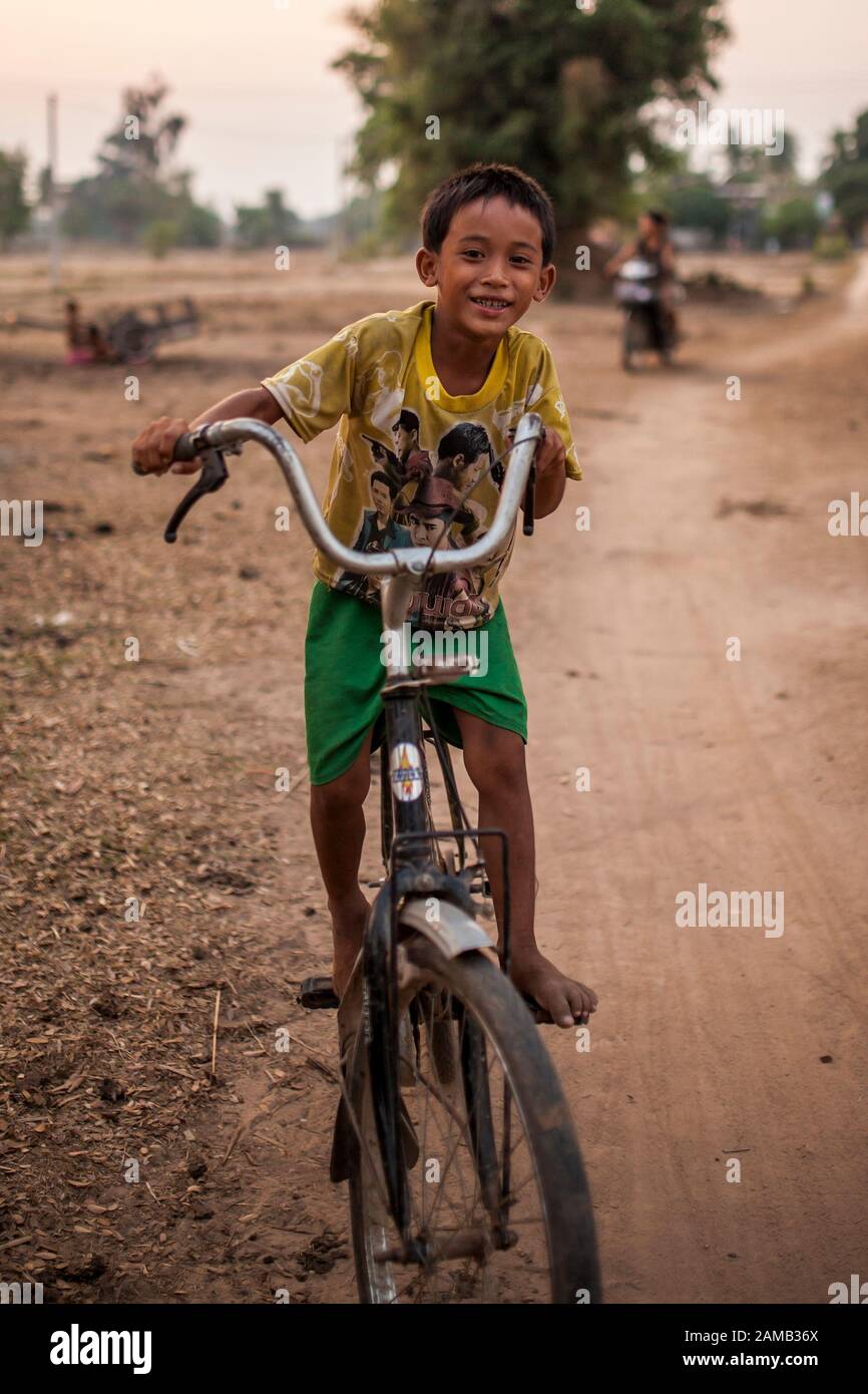 Don DET, LAOS - 5 APRILE 2013: Un ragazzo non identificato guida una bicicletta attraverso il villaggio di Don Det, Laos. Foto Stock