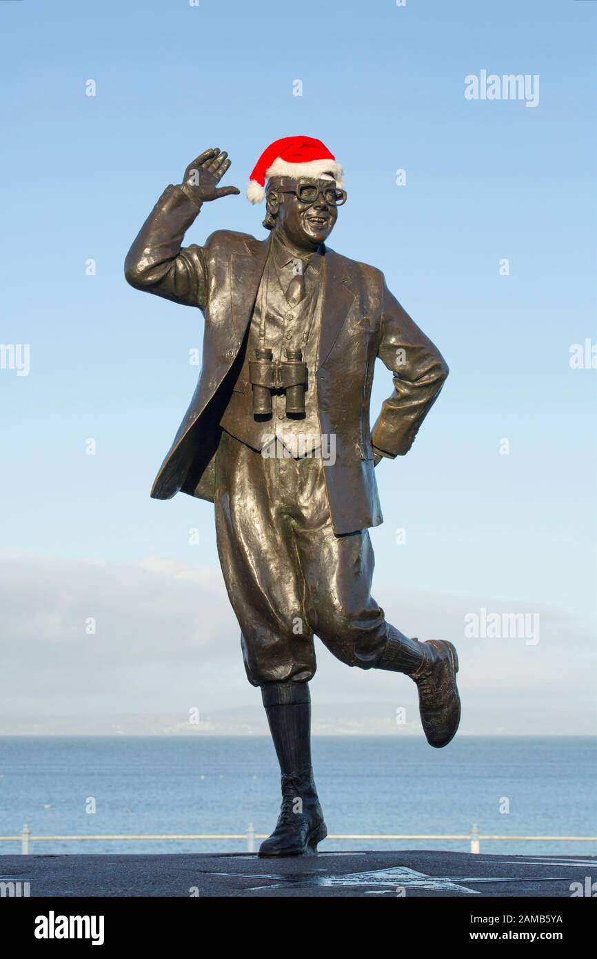 Una statua del comico Eric Morecambe sul lungomare di Morecambe il giorno di Natale 2019. Un cappello di Babbo Natale è stato messo sulla statua. Eric Morecamb Foto Stock