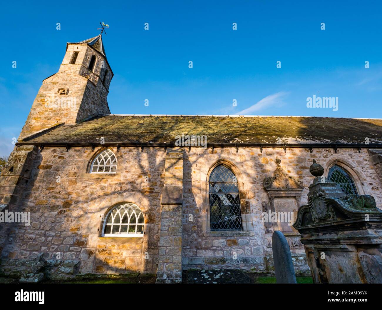 Pencaitland Parish Church (Chiesa di Scozia) 17th secolo chiesa con cielo soleggiato e vecchie tombe, East Lothian, Scozia, Regno Unito Foto Stock