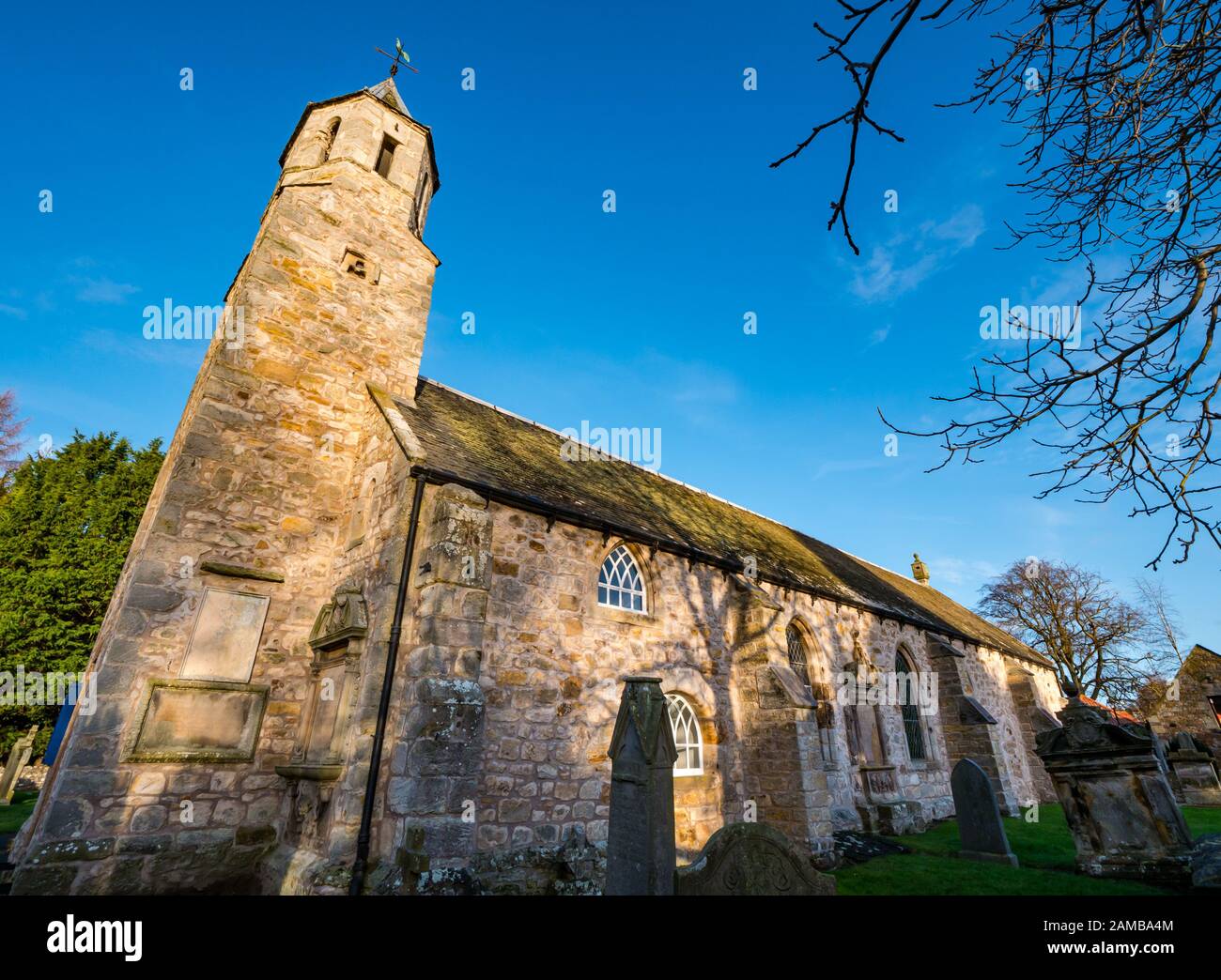 Pencaitland Parish Church (Chiesa di Scozia) 17th secolo chiesa con cielo soleggiato e vecchie tombe, East Lothian, Scozia, Regno Unito Foto Stock