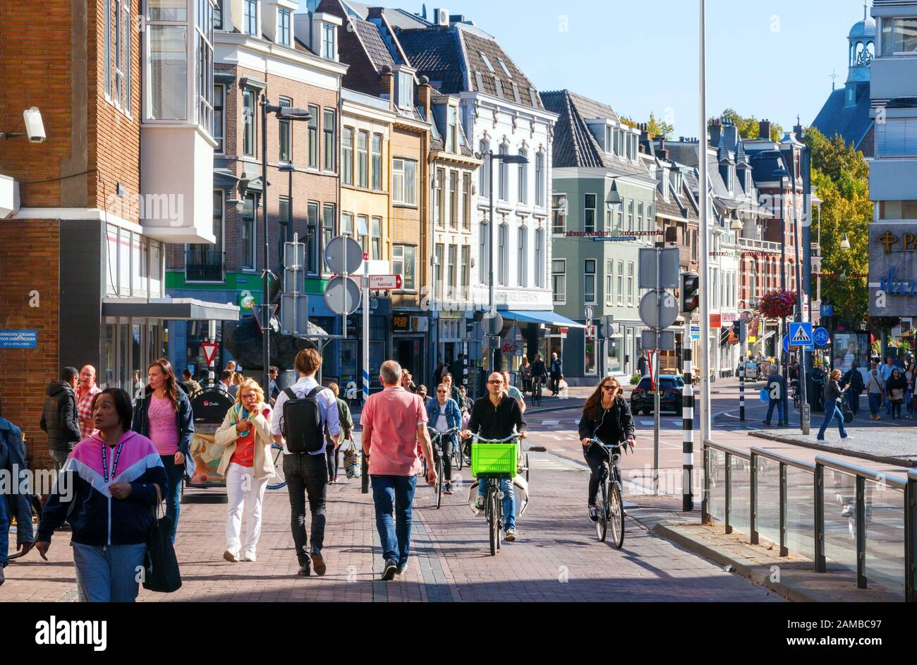 Centro di Utrecht, frequentato da ciclisti e pedoni non identificati, al Lange Jansstraat, in un pomeriggio soleggiato. Paesi Bassi. Foto Stock