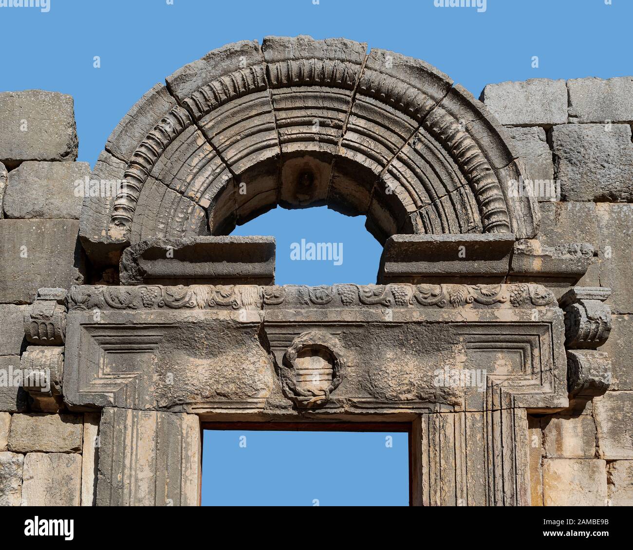 isolato ritaglio del architrave di pietra e arco di una porta in una sinagoga di epoca talmudica nel parco nazionale di bar'am in israele su uno sfondo blu cielo Foto Stock