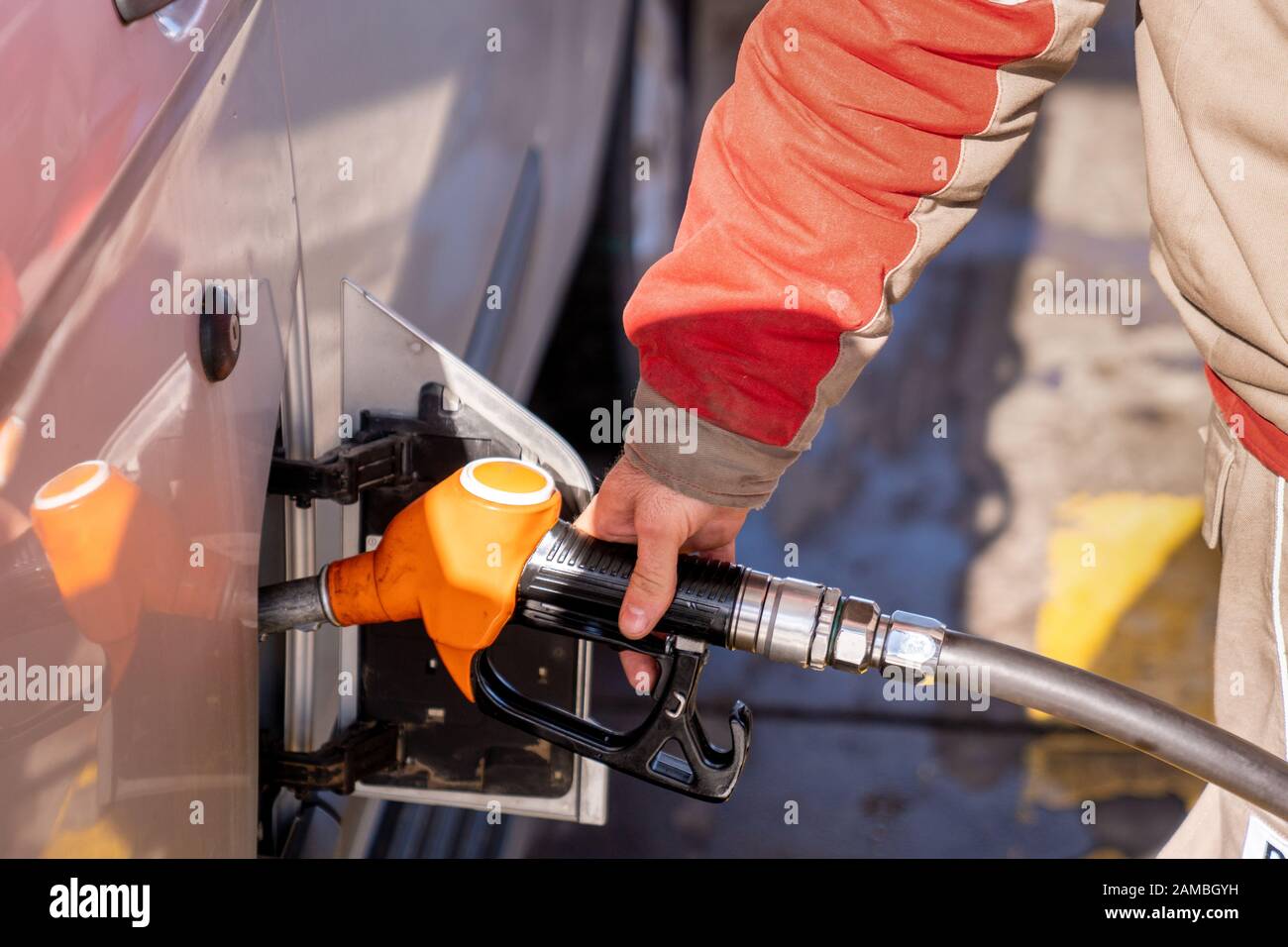 Il personale della stazione di benzina sta pompando combustibile per un automobile. Foto Stock