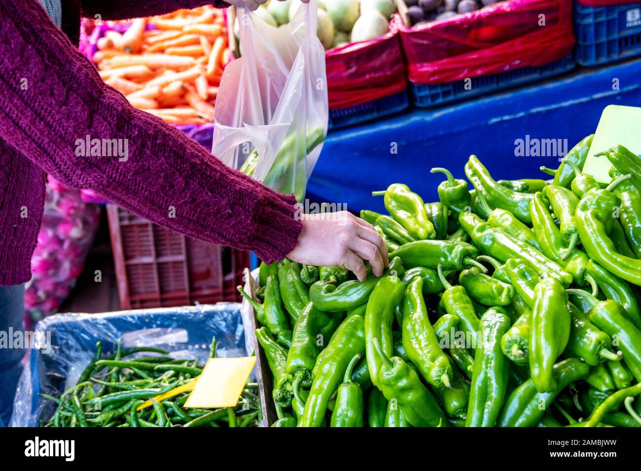 Scegliendo il peperone verde di verdure molto fresco da un mucchio in una drogheria Foto Stock