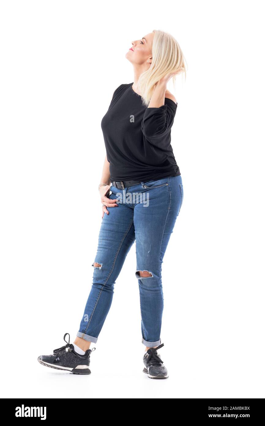 Matura mezza età bionda capelli donna regolare e toccare capelli spensierati. Corpo intero isolato su sfondo bianco. Foto Stock