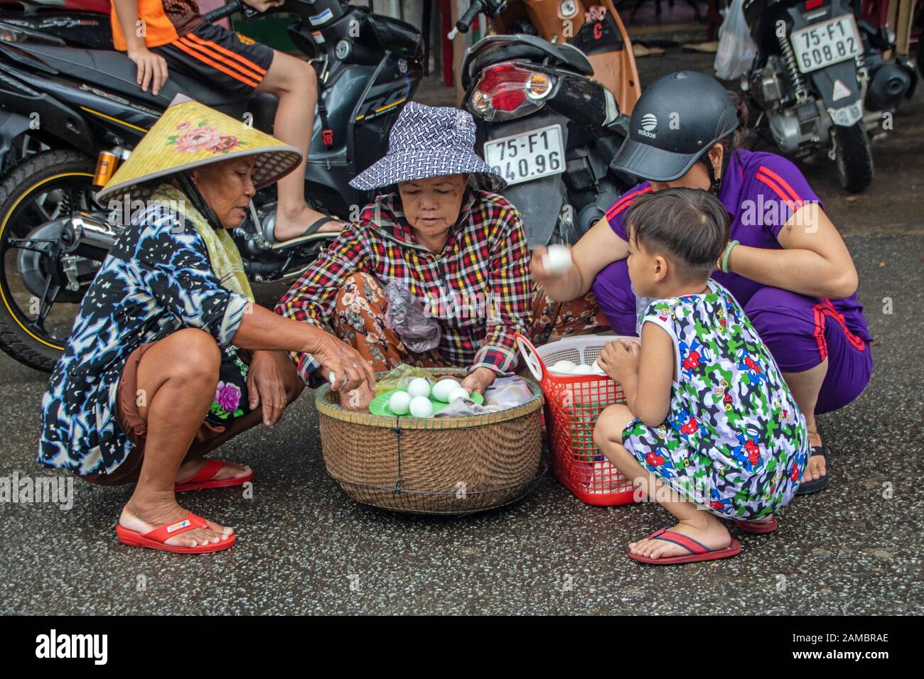 A Hue - Vietnam - L'agosto 2019 - donne e bambini con un cesto di uova al mercato di Dong Ba, il più antico mercato di Hue City Foto Stock