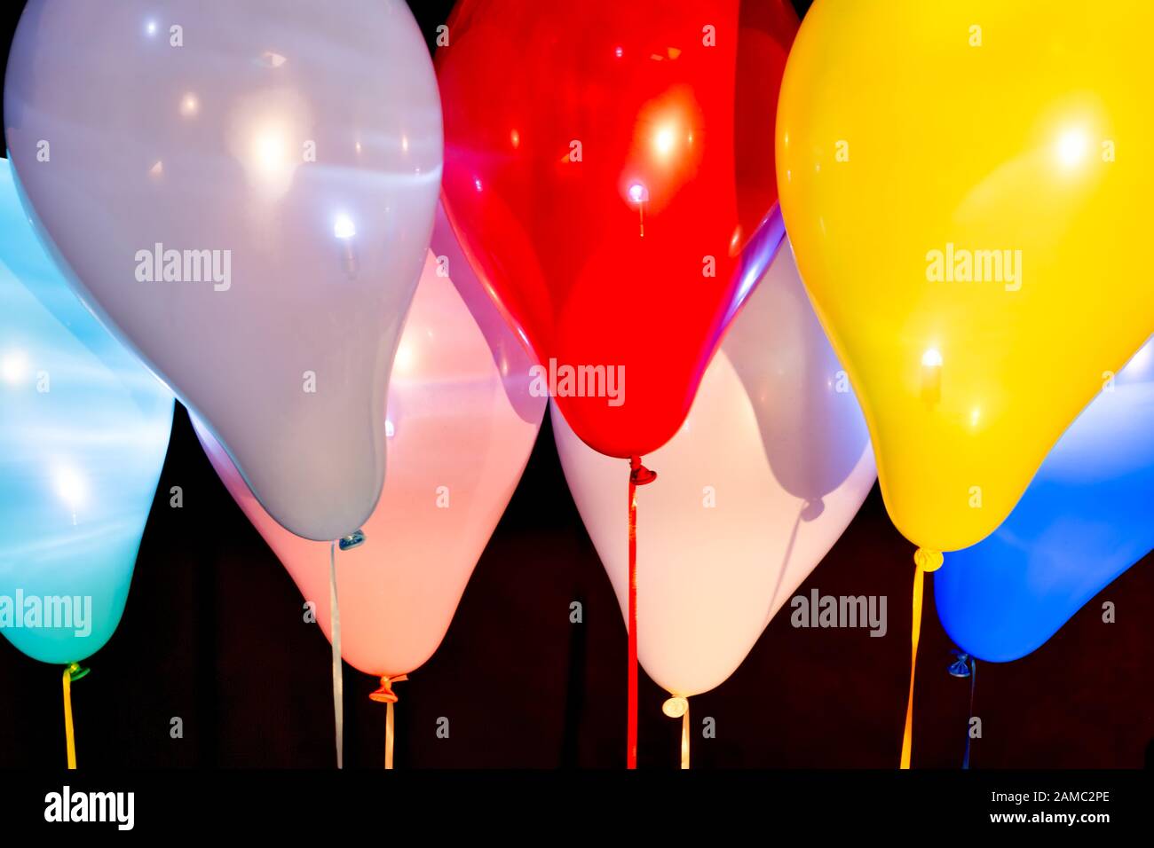 Palloncini colorati illuminati con LED su sfondo scuro Foto stock - Alamy