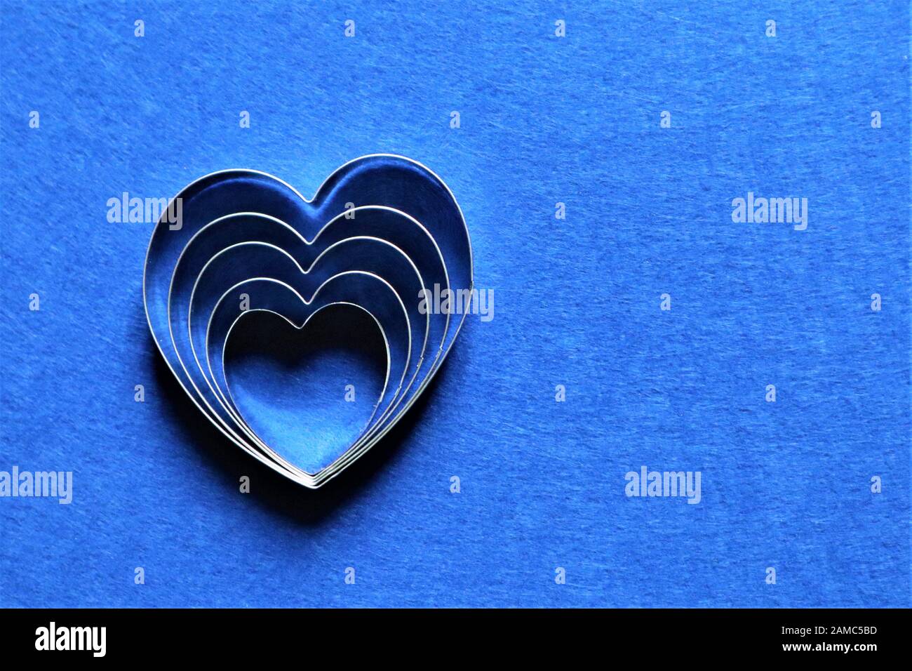 Molti cuori nel colore alla moda del 2020 sul classico sfondo blu. Copia dello spazio. Foto Stock
