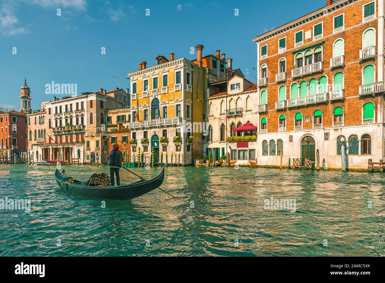 Gondola gondolier veneziana attraverso il Canal Grande lungo le facciate colorate dell'edificio a Venezia, Italia Foto Stock