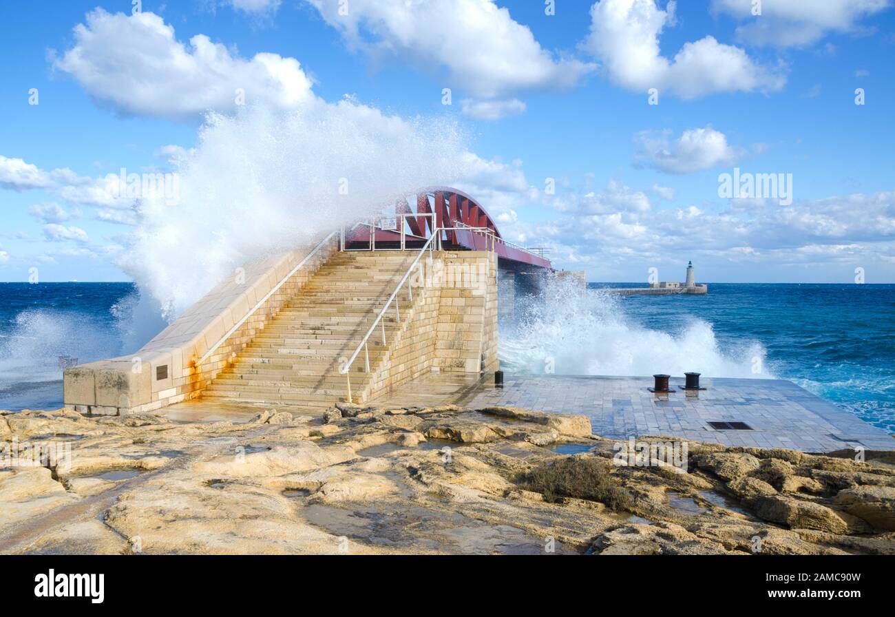 VALLETTA, MALTA. 29th dicembre 2019. Nelle prime fasi di una tempesta invernale, le onde si infrangono sul Breakwater Bridge (St. Elmo Breakwater) In Valletta Gra Foto Stock