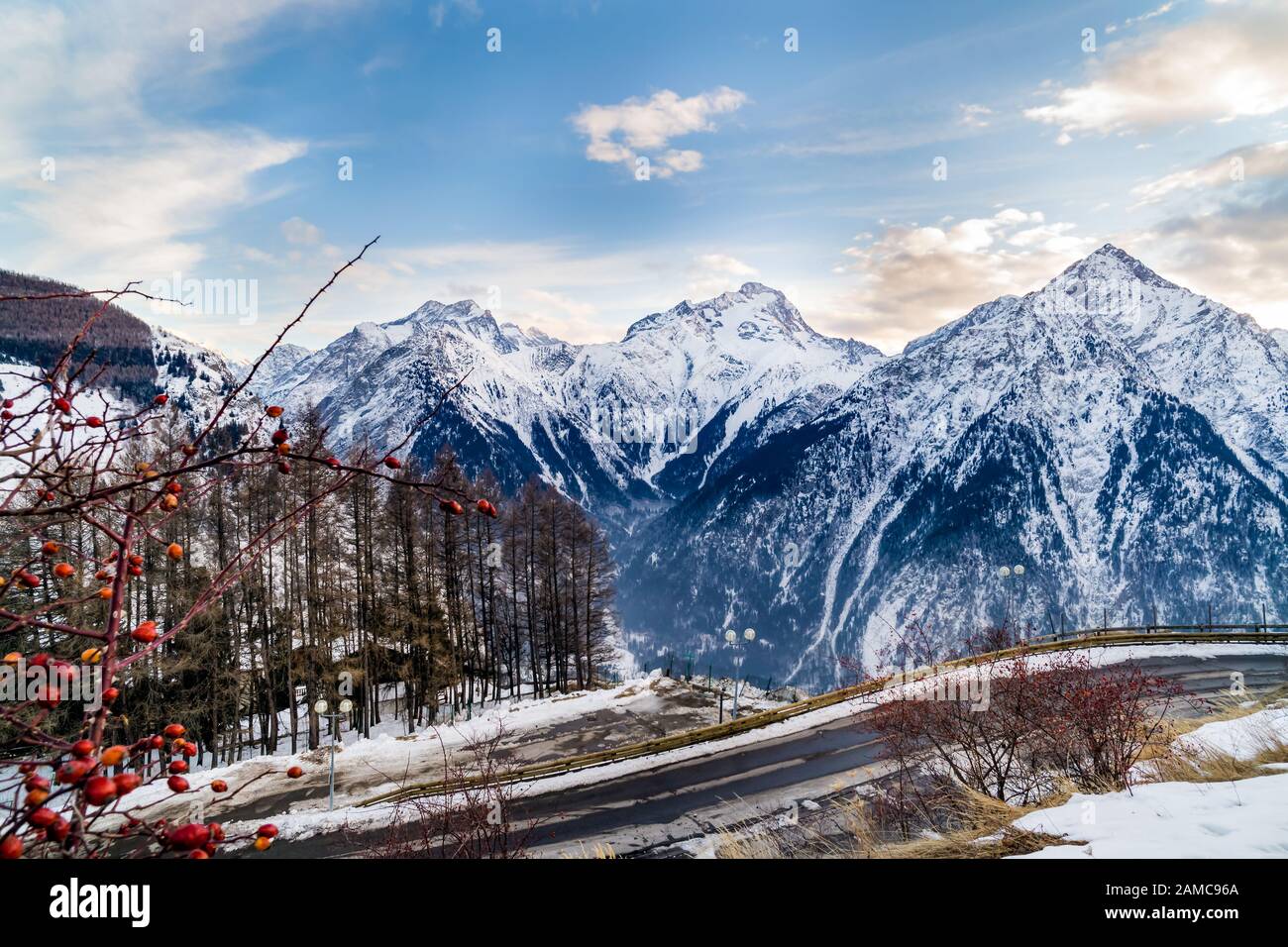 Vista dalla periferia di Les deux Alpes villaggio sulla catena montuosa con nebbia o nebbia nella valle sottostante. Tramonto sulle alpi francesi, regione del Rodano-Alvernia, Francia Foto Stock
