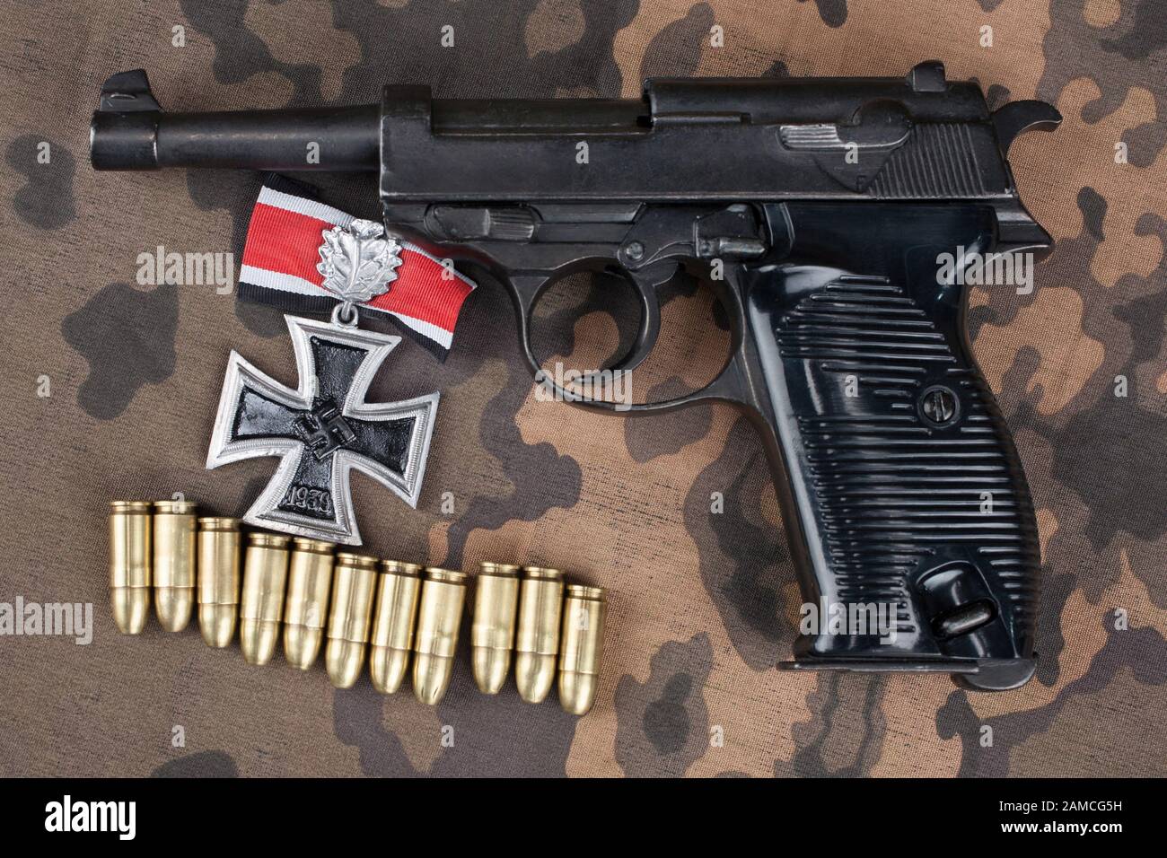 Durante la Seconda guerra mondiale era nazista esercito tedesco 9 mm pistola semi-automatica con croce in ferro sul premio mimetizzata sfondo uniforme Foto Stock