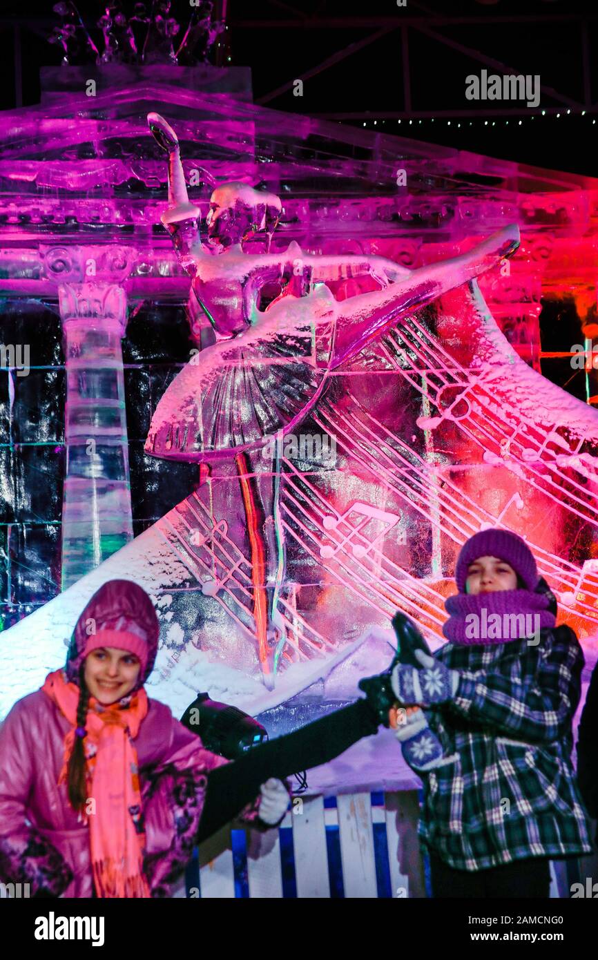 Mosca, Russia. 12th Gen 2020. Le ragazze posano per una foto con una scultura di ghiaccio di una ballerina al festival di Mosca di ghiaccio, in Russia, 12 gennaio 2020. Al festival sono state presentate più di 100 sculture di ghiaccio, raffiguranti notevoli esempi di patrimonio nazionale russo e realizzazioni dall'antichità fino all'epoca moderna. Credito: Maxim Chernavsky/Xinhua/Alamy Live News Foto Stock