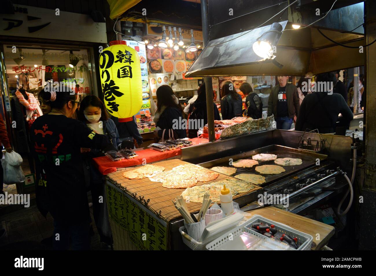 Bancarelle di cibo che vendono pancake salati coreani nel vivace mercato alimentare di Tsuruhashi, Osaka. Foto Stock