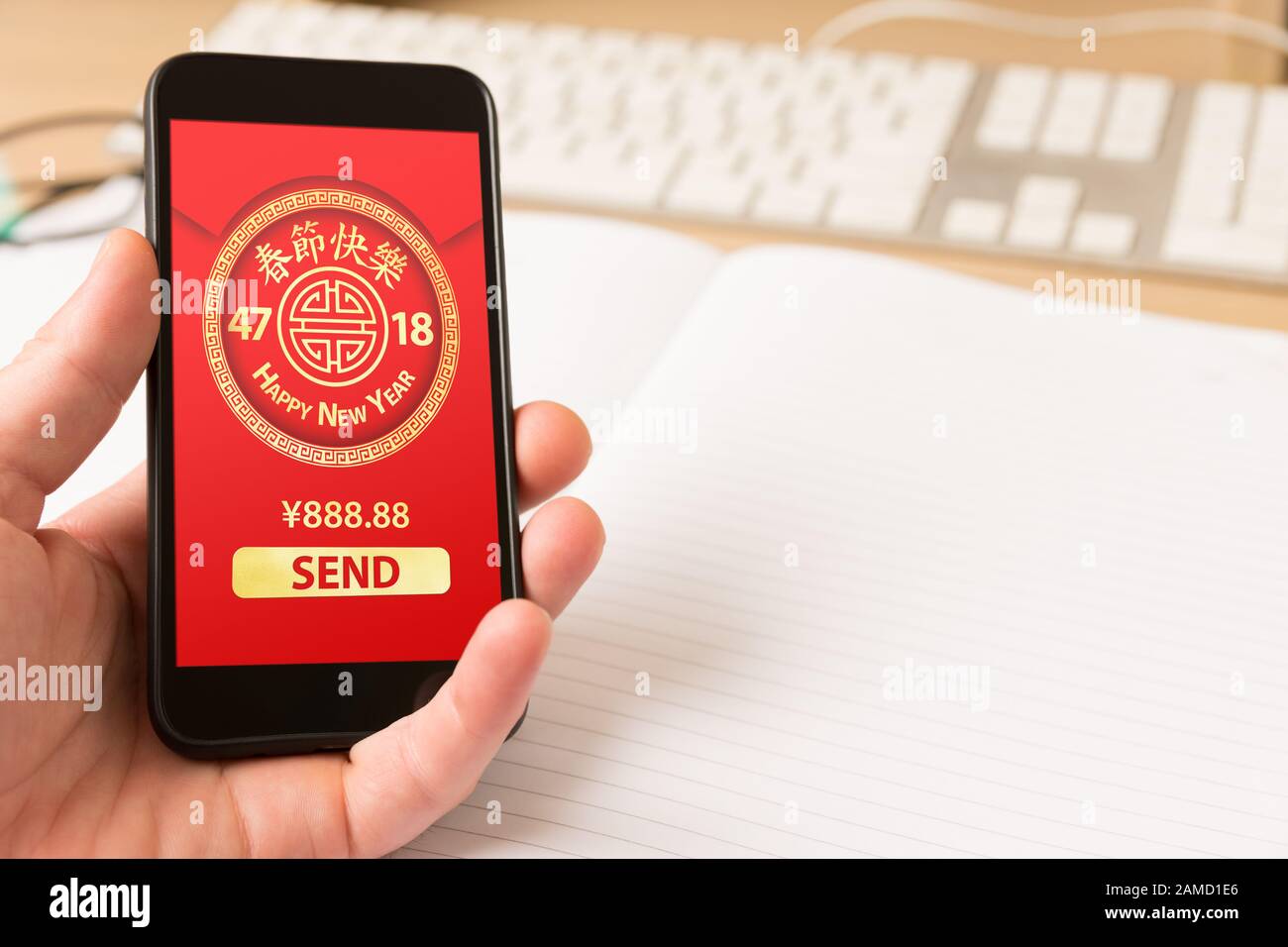 Tenere a mano lo smartphone con pacchetto digitale rosso per il nuovo anno cinese visualizzato sullo schermo - feste e concetto di tecnologia. Foto Stock
