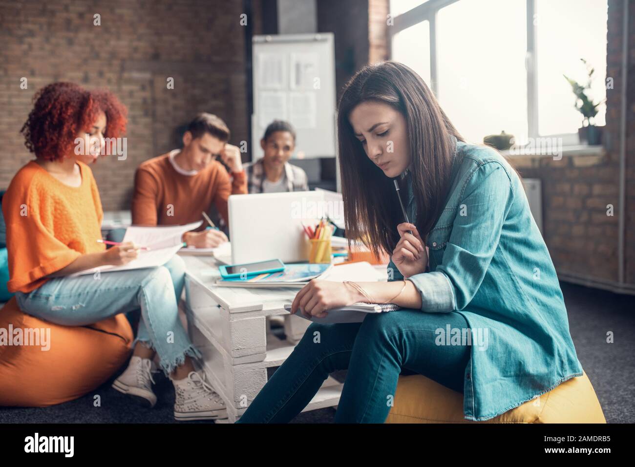 La sensazione di uno studente intelligente dai capelli scuri si è concentrata sul linguaggio di apprendimento Foto Stock