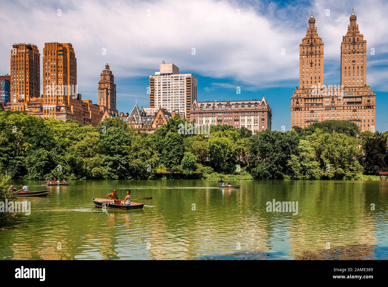 NYC, NY / USA - 12 Luglio 2014: La gente fila nel Lago del Central Park con lo skyline di Upper West Side Manhattan sullo sfondo. Foto Stock