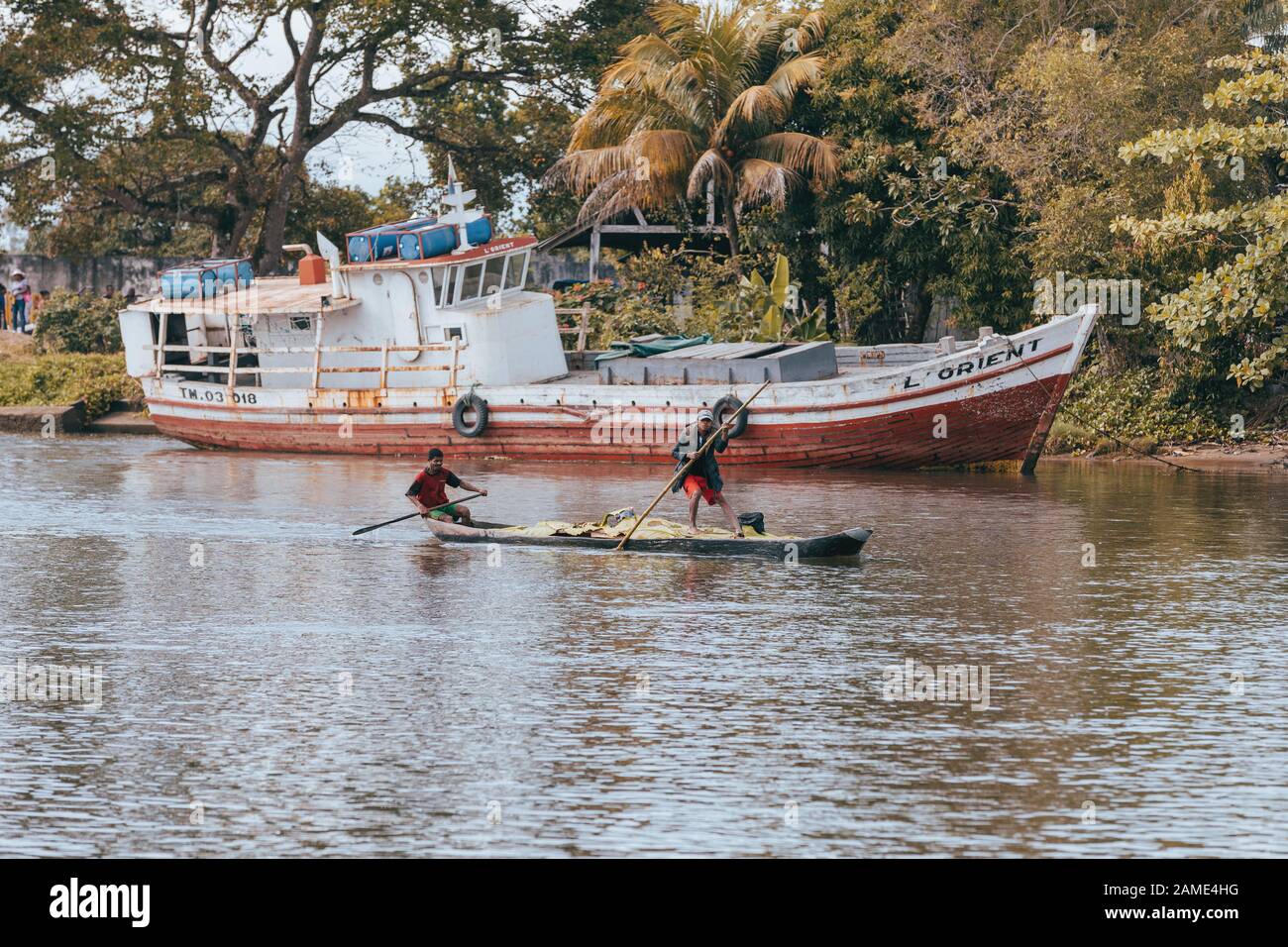 Maroantsetra, MADAGASCAR 19.OTTOBRE 2016: Le persone malgasce trasportano merci con piroga tradizionale in legno lavorato a mano. Vita quotidiana sul fiume Antaamba Foto Stock