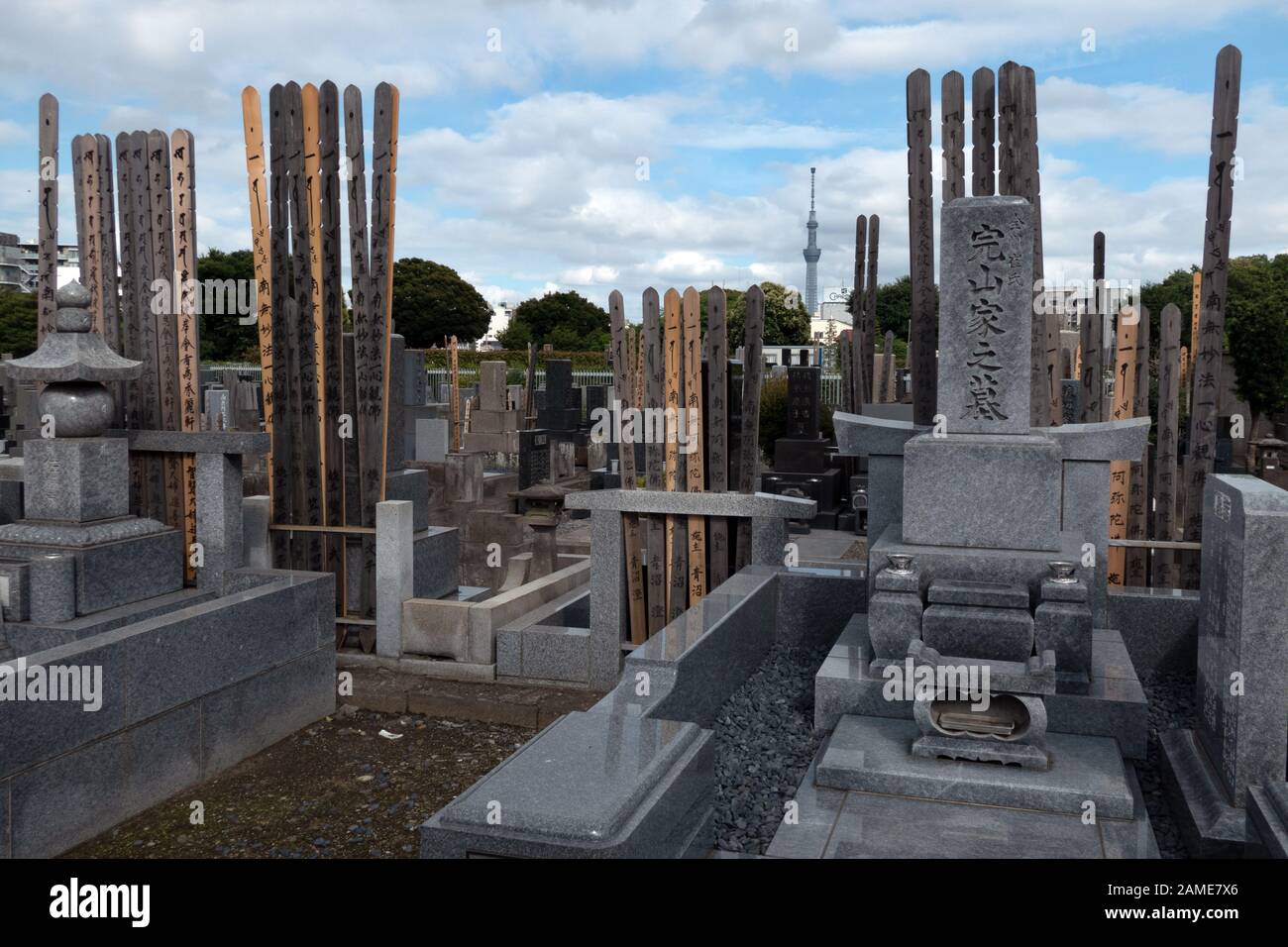 Cimitero di Yanaka a Tokyo, Giappone, Asia. Vecchio cimitero giapponese con tombe e tombe. Skytree Tower sullo sfondo Foto Stock
