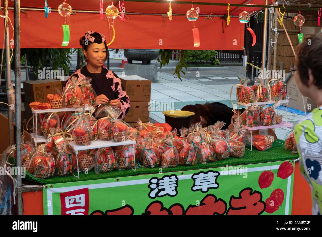 Donna Alkekengi Vendita fiori in Tokyo, Giappone, Asia. Tradizionale Giapponese del mercato detenuto in Asakusa attorno al Tempio di Senso-ji ogni anno il 9 e 10 luglio Foto Stock