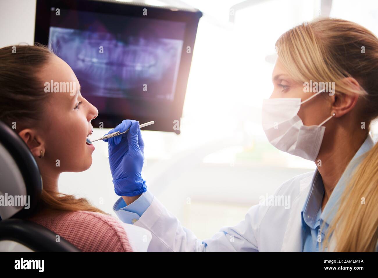 Ortodontista femminile che usa lo specchio dentale durante il controllo Foto Stock