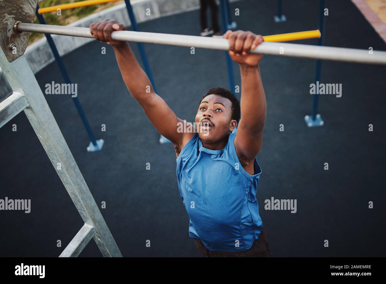 Montare giovane uomo nero facendo tirare su ad una palestra all'aperto Foto Stock