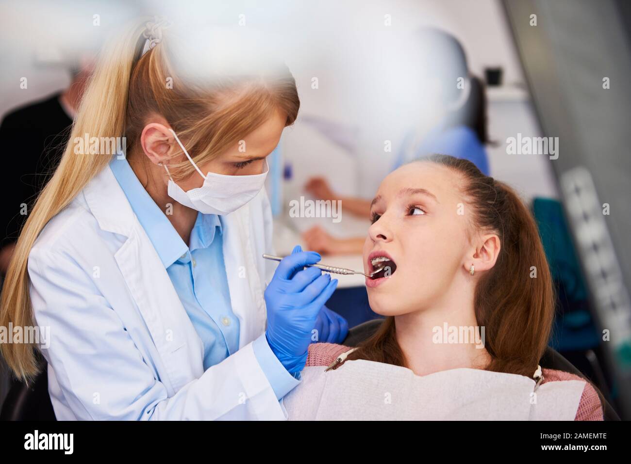 Ortodontista femminile che esamina i denti del bambino Foto Stock