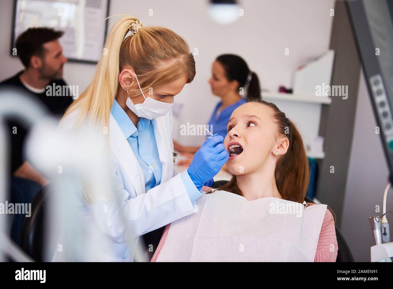 Ortodontista messo a fuoco usando specchio dentale Foto Stock