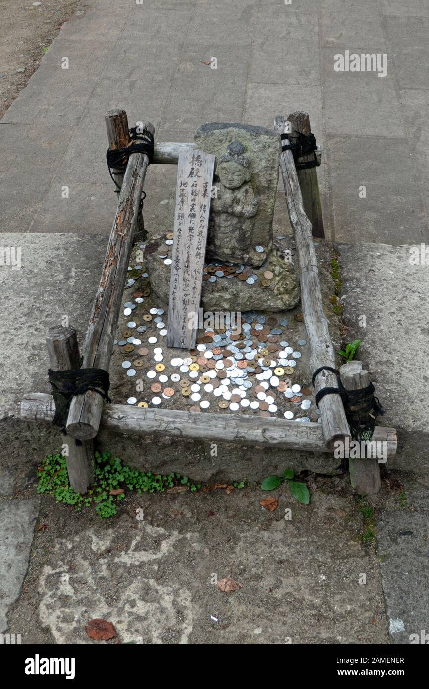 Denaro e monete gettate da persone e pellegrini al tempio di Yamadera o Yama-dera in Giappone, Asia. Edificio religioso giapponese e santuario buddista Foto Stock