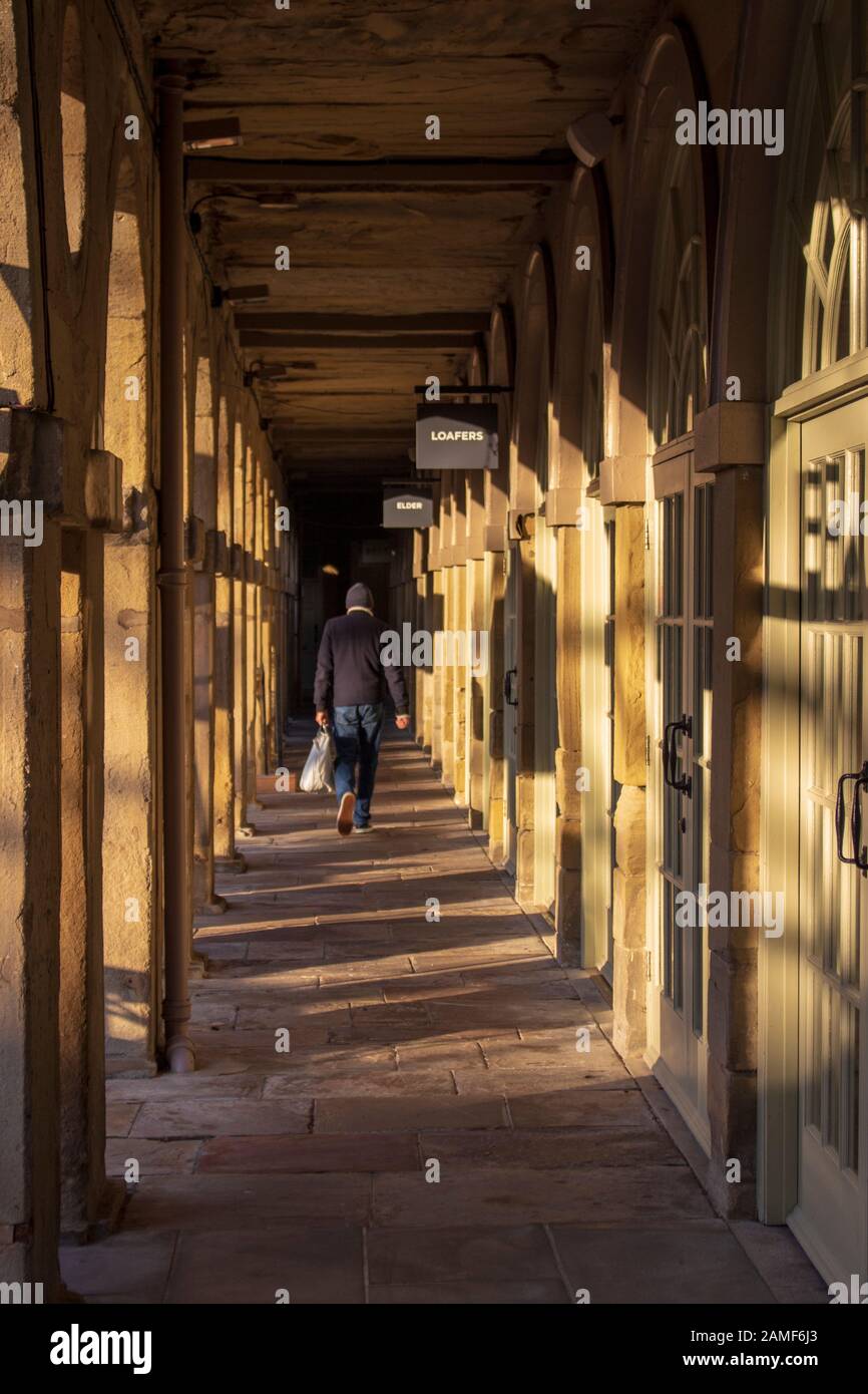 Corridoio di luce l'ombra dell'edificio e un uomo a piedi attraverso Foto Stock