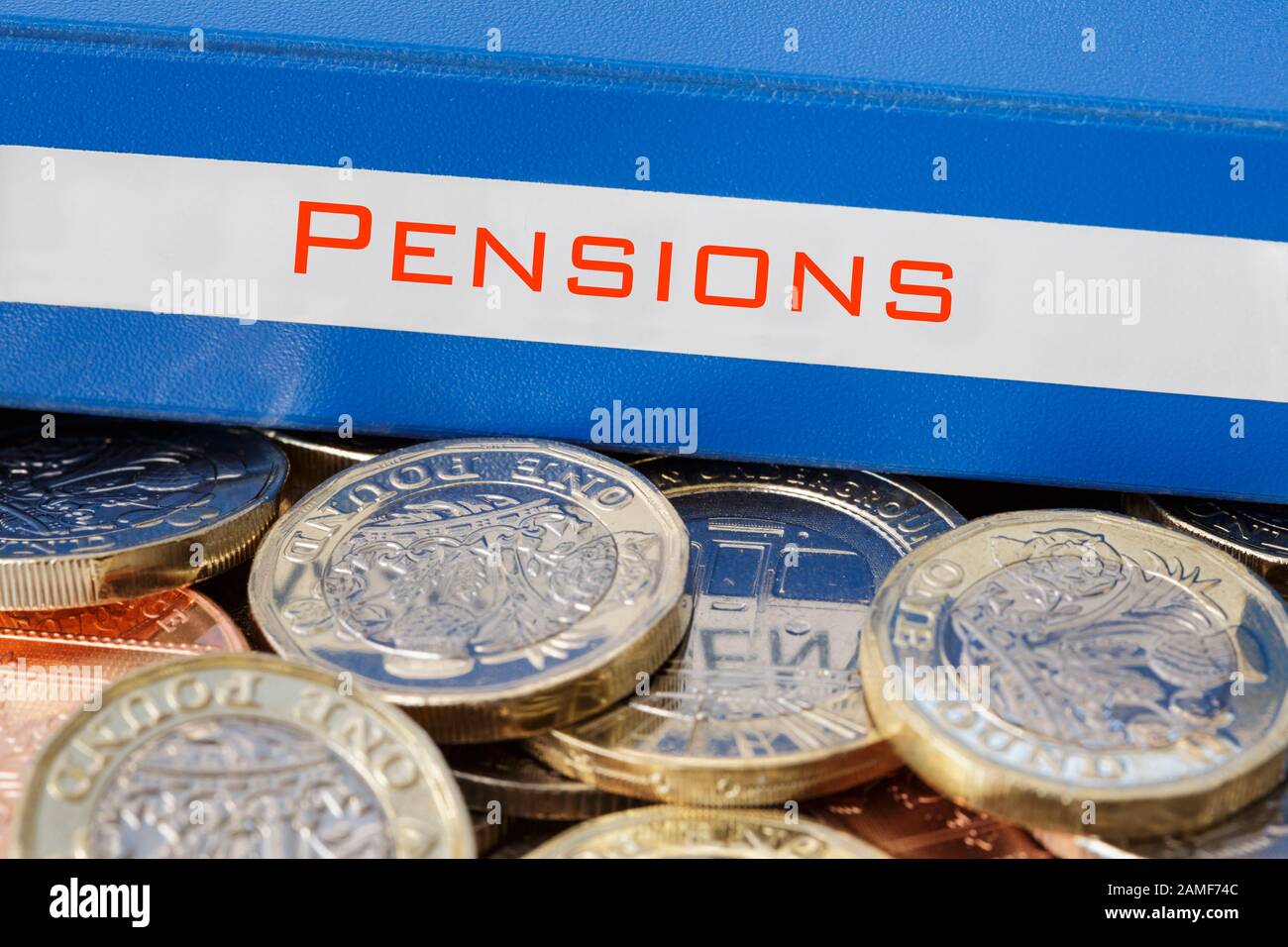 Cartella di risparmio di pensioni su un mucchio di sterline denaro nuovo £ sterlina monete. Illustrare il risparmio per un concetto di pensione. Inghilterra Gran Bretagna Foto Stock