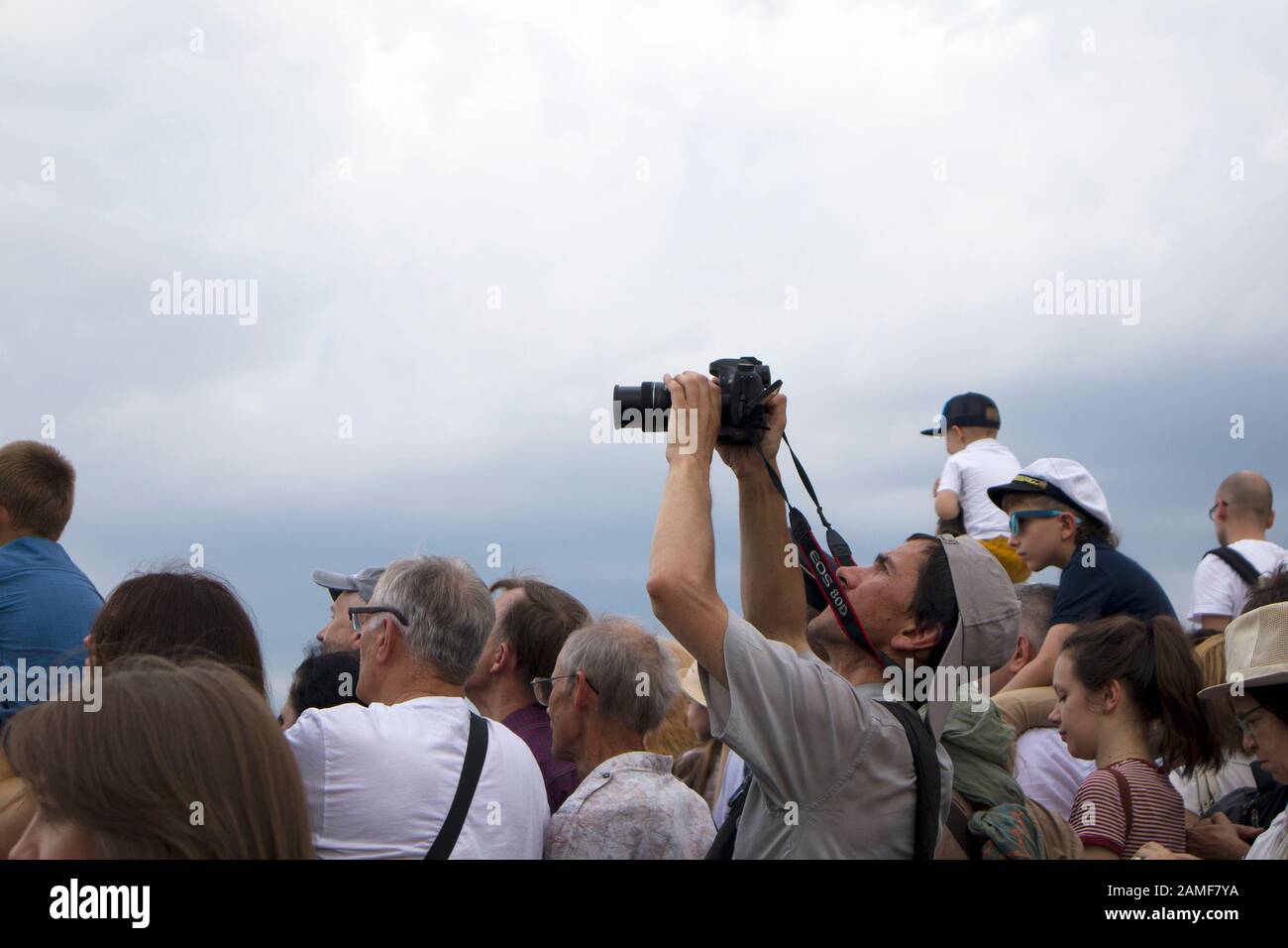 San Pietroburgo, Russia, 28 luglio 2019. Uomo con fotocamera prestazioni di scatto sopra le teste delle persone durante la giornata della Marina Militare Foto Stock