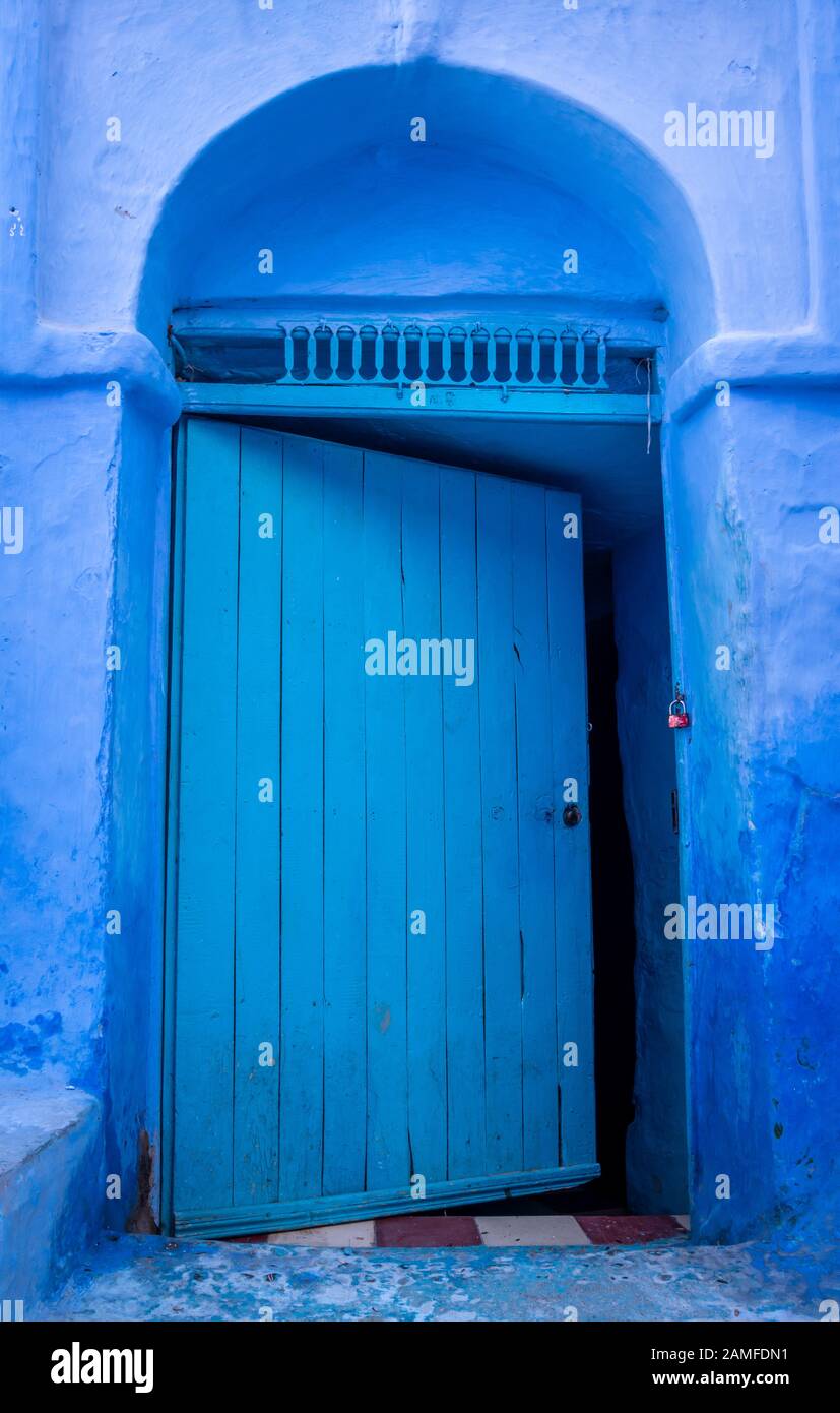 Porta blu a metà apertura a Chefchaouen, Medina, Marocco Foto Stock
