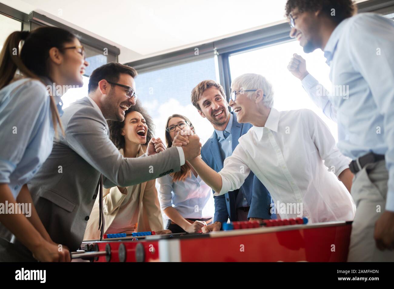 Multirazziale persone divertirsi in ufficio, eccitati diversi dipendenti godendo di attività sul posto di lavoro Foto Stock