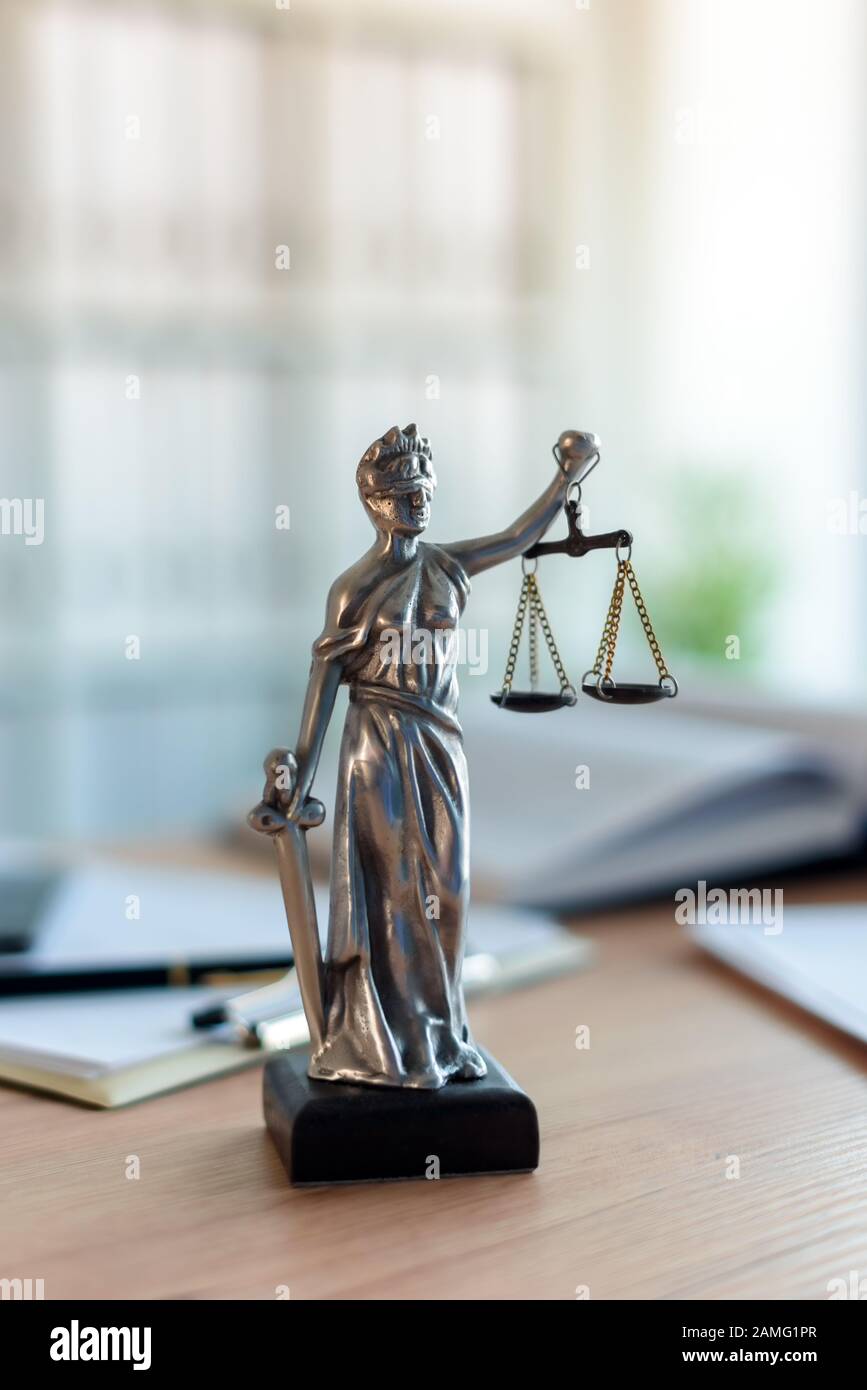 Signora giustizia statua in studio legale avvocato office, con gli occhi bendati Justitia con bilance di precisione e la spada è la personificazione della forza morale giudiziaria sist Foto Stock
