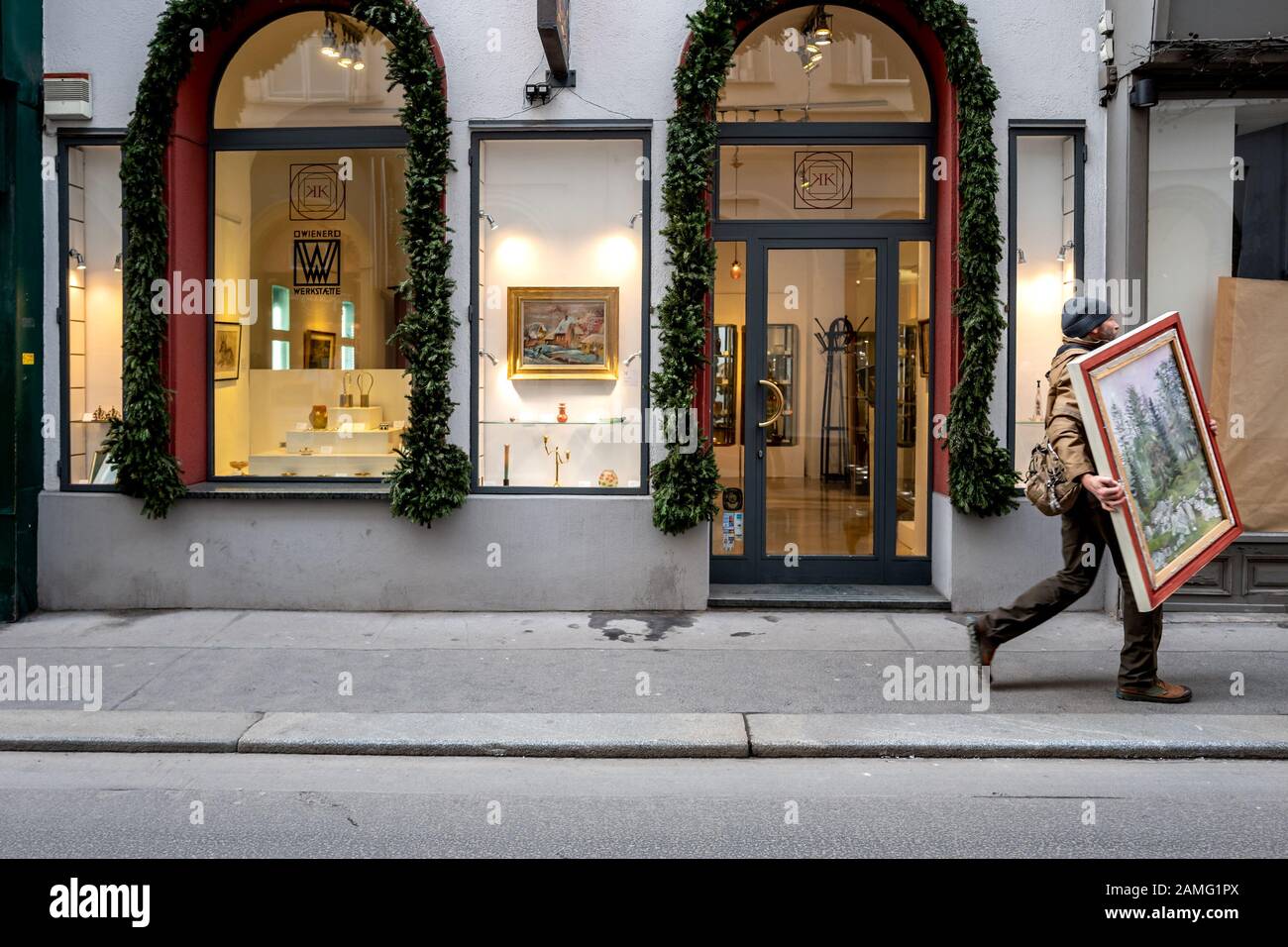 Un uomo che porta una pittura attraverso le strade di Vienna, Austria Foto Stock