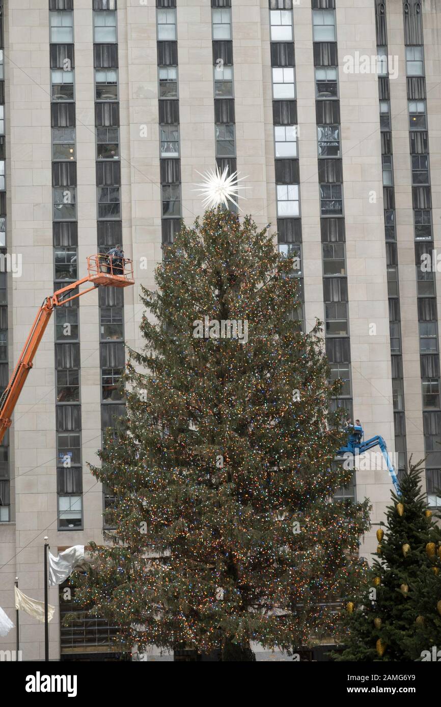 I lavoratori frequentano l'enorme albero di Natale del Rockefeller Center durante la stagione delle vacanze, New York City, USA Foto Stock