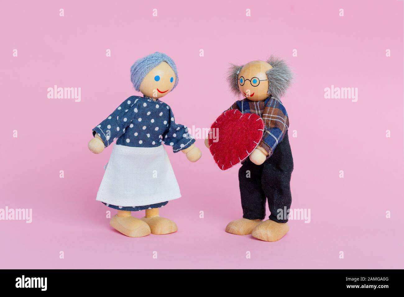 Bambole anziano uomo e donna. Nonno nonna dà un cuore un simbolo di amore e di fiducia. Il giorno di San Valentino, l'amore. Foto Stock