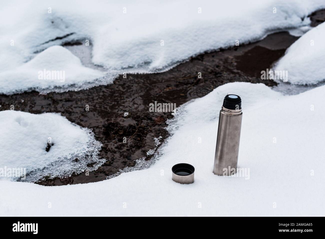 matraccio da vuoto sulla neve vicino al torrente di montagna che scorre Foto Stock