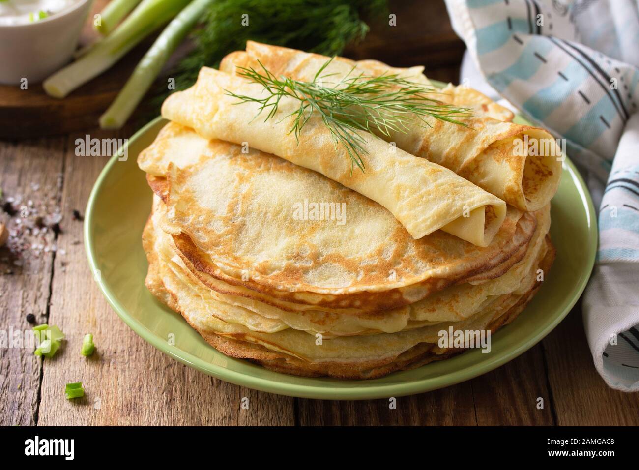 Frittelle di patate, non dolci, servite con salsa di crema all'aglio su un rustico tavolo di legno. Foto Stock