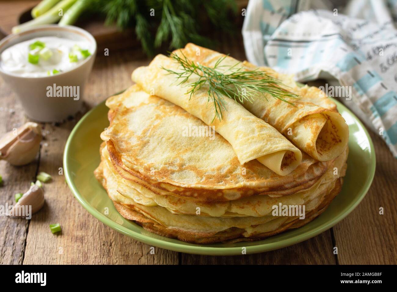 Frittelle di patate, non dolci, servite con salsa di crema all'aglio su un rustico tavolo di legno. Foto Stock