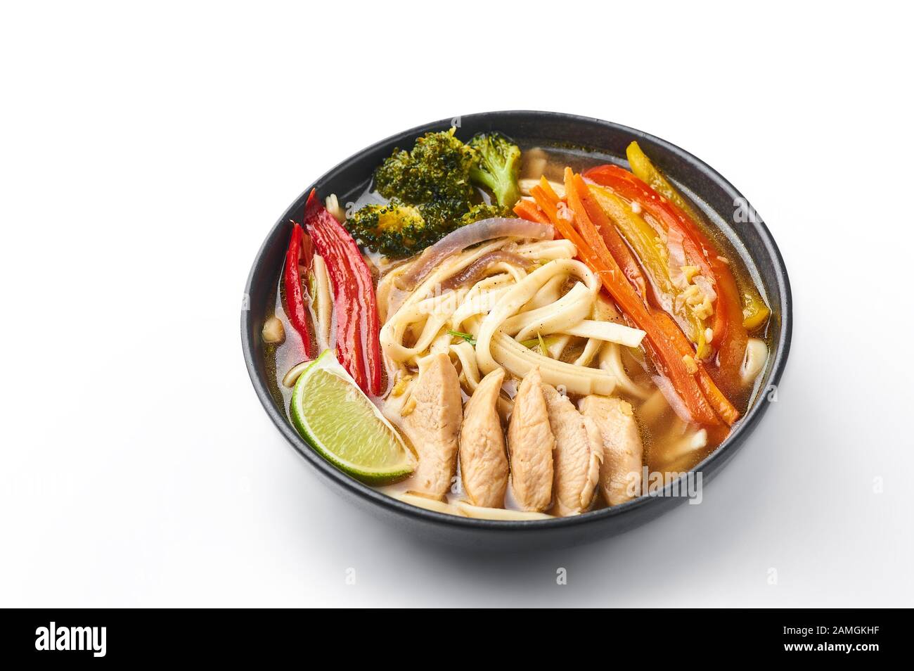 Pollo Thukpa in ciotola nera isolato a sfondo bianco. Il pollo Thukpa è una zuppa di noodle di cucina tibetana con verdure e carne di pollo. Foto Stock