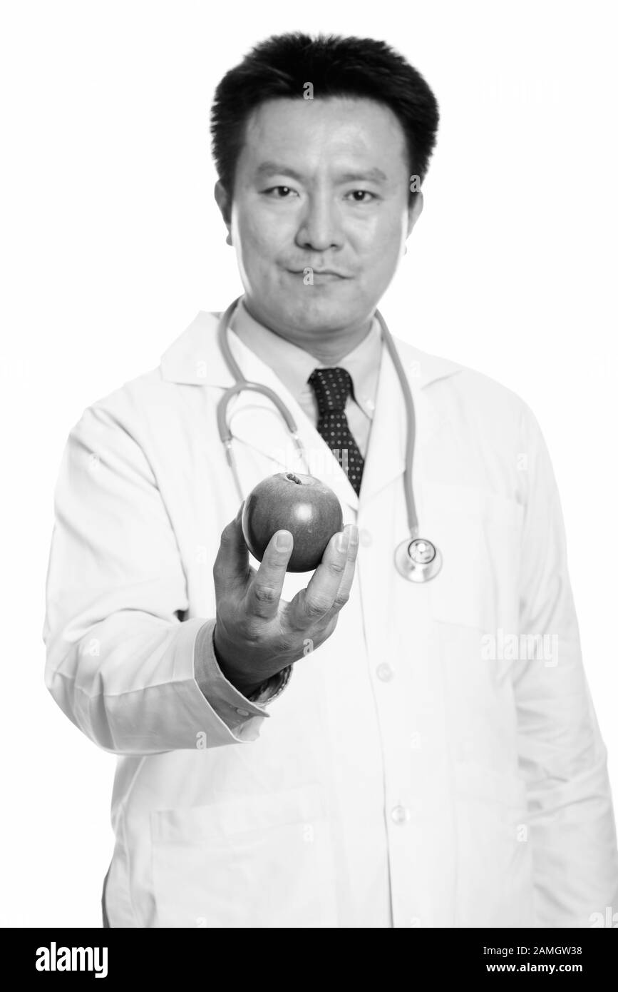 Studio shot di giapponese uomo medico azienda red apple con focus su apple Foto Stock