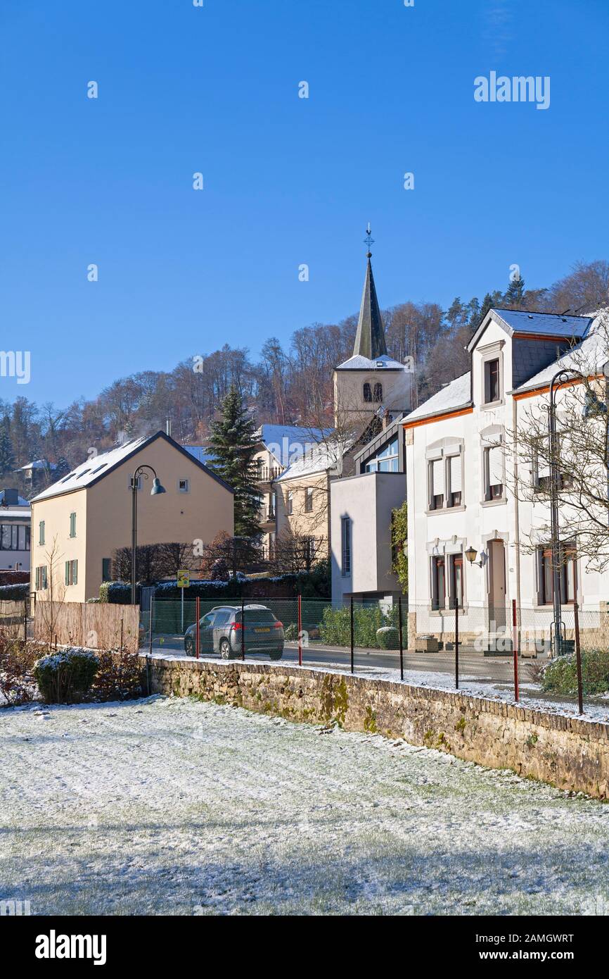 Europa, Lussemburgo, Septfontaines, Village Centre con Chiesa di Saint-Martin E Alloggio su Mierscherstross nella neve Foto Stock