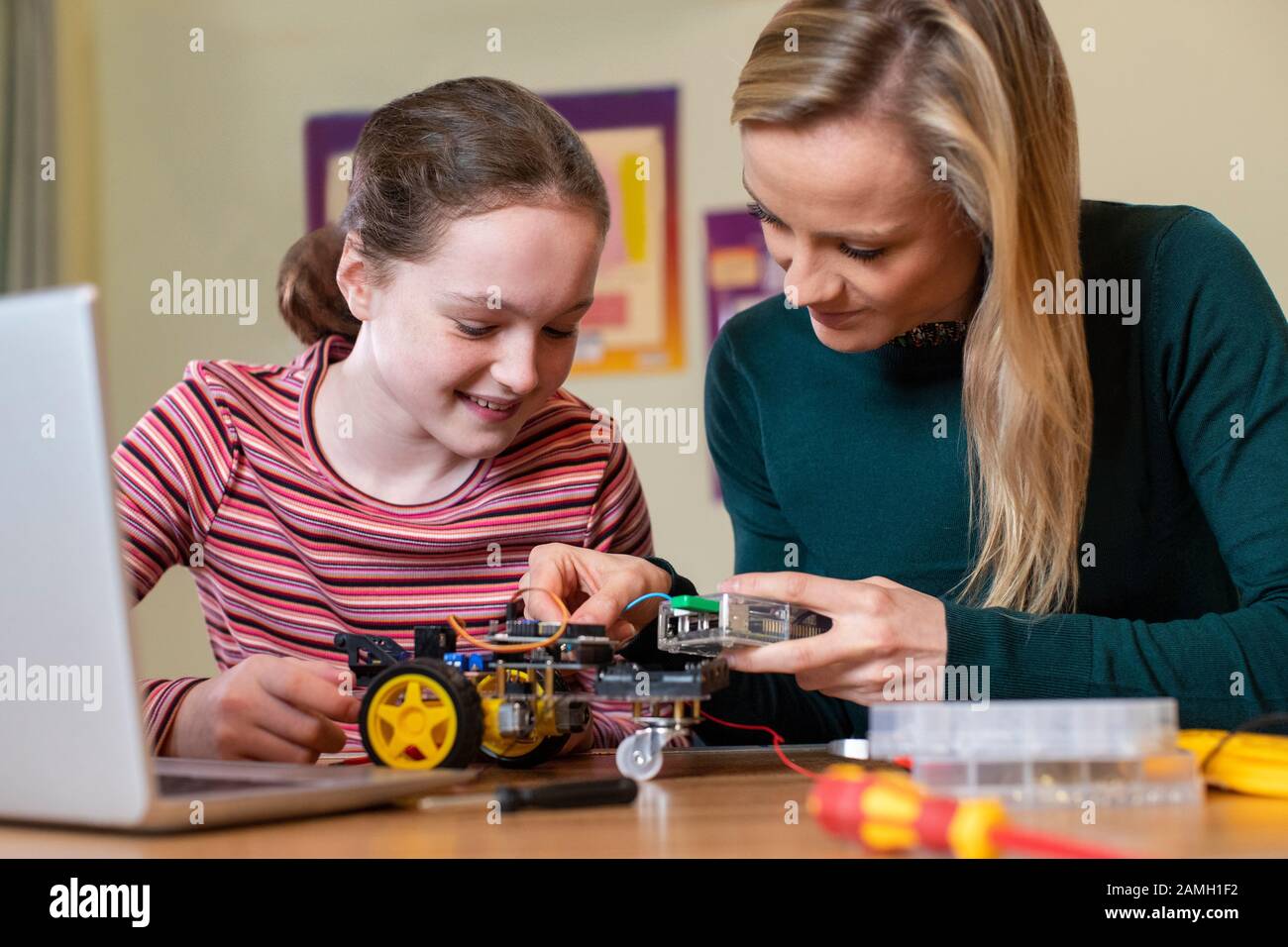 Insegnante Che Aiuta La Pupilla Femminile A Costruire La Macchina Del Robot Nella Lezione Di Scienza Foto Stock