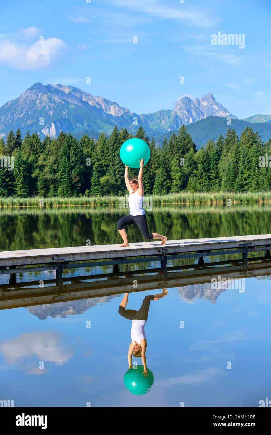 Donna facendo ginnastica Pilates con sfera Foto Stock